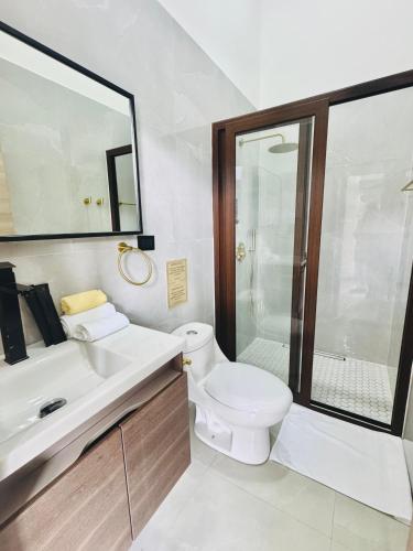 a white bathroom with a toilet and a sink at NEW YORK by luxury atitlan in San Pedro La Laguna