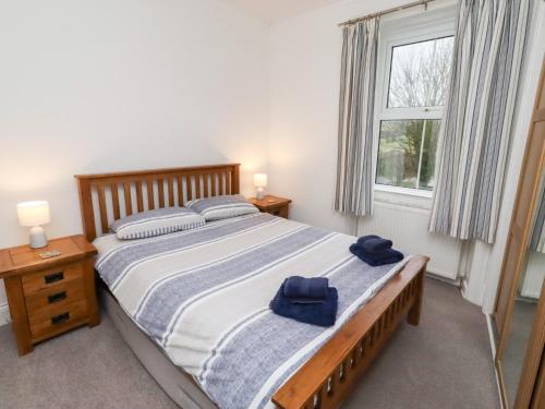 a bedroom with a large bed with blue towels on it at Riverside Cottage in Warkworth