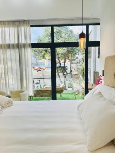 a bedroom with a large bed and a large window at NEW YORK by luxury atitlan in San Pedro La Laguna