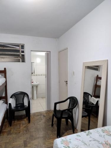 a bedroom with two beds and a mirror and a bathroom at Centro de Convenções - Hospedagem in Recife