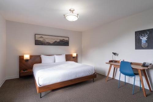 a hotel room with a bed and a desk and a bed and a desk at Adara Hotel in Whistler
