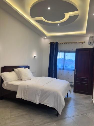 a bedroom with a bed with a coffered ceiling at Résidence Prestige KGV Appt 303 in Douala