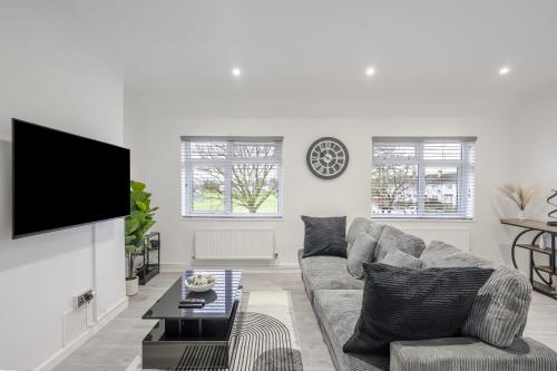 a living room with a couch and a tv at Chic & Cosy 2 Bed Maisonette with Freeparking near Chelmsford City Centre in Chelmsford