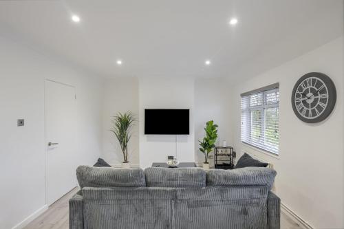 a living room with a couch and a tv at Chic & Cosy 2 Bed Maisonette with Freeparking near Chelmsford City Centre in Chelmsford