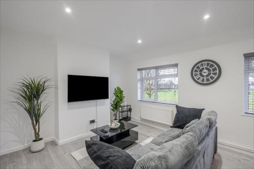 a white living room with a couch and a tv at Chic & Cosy 2 Bed Maisonette with Freeparking near Chelmsford City Centre in Chelmsford