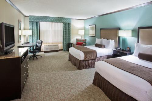 a hotel room with two beds and a flat screen tv at Crowne Plaza Anchorage-Midtown by IHG in Anchorage