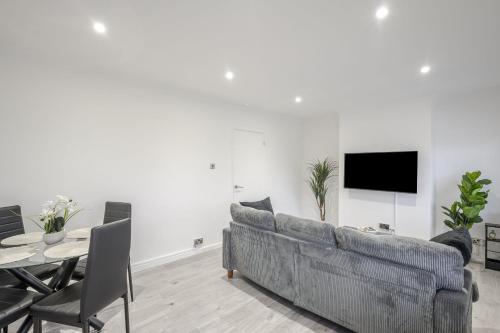 a living room with a couch and a table and a tv at Chic & Cosy 2 Bed Maisonette with Freeparking near Chelmsford City Centre in Chelmsford