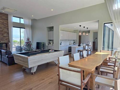 a living room with a pool table and a kitchen at Sa Prung on the mountain - สะพรั่งกลางขุนเขา in Ban Tham