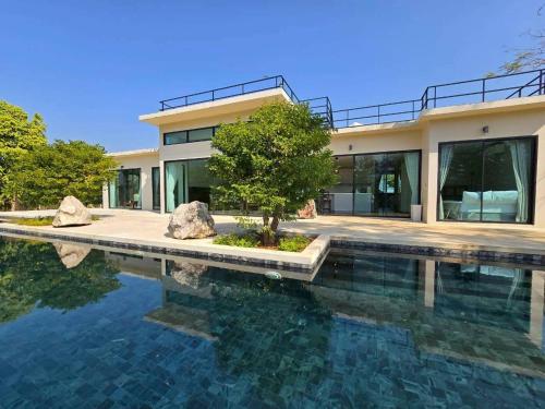 a house with a swimming pool in front of a house at Sa Prung on the mountain - สะพรั่งกลางขุนเขา in Ban Tham