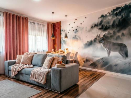 a living room with a couch and a painting of a deer at Apartamenty koło Szczyrku A&S Spa - basen, jacuzzi, sauna in Szczyrk
