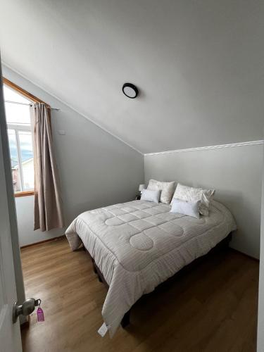 a bedroom with a bed with a clock on the wall at Casa Jesy in Frutillar