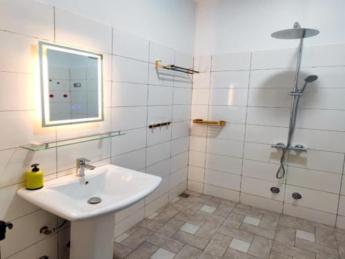 een witte badkamer met een wastafel en een douche bij Maison Recla in Lomé