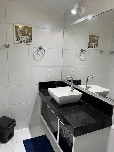 a white bathroom with a sink and a mirror at Espaço Ybirá in Marechal Deodoro