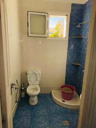 a bathroom with a toilet and a sink and a window at V résidence in Ḩamādat al Kebalou
