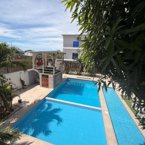 a large blue swimming pool next to a building at Preciosa Suite Familiar para 10 personas con cocina y 3 piscinas in Playas