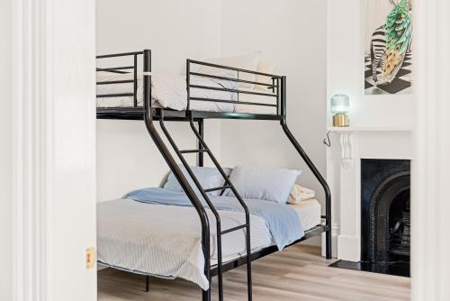 a black bunk bed in a room with a fireplace at Belle Escapes - The Light House in Glenelg