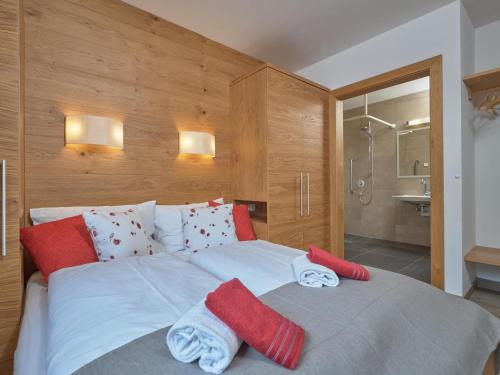 a bedroom with a large bed with red and white towels at BergbiberHAUS Top A in Piesendorf