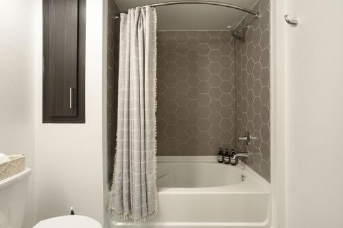 a bathroom with a bath tub with a shower curtain at Luxury 1BDR centrally located in Hollywood in Los Angeles