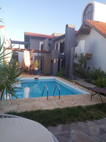 a swimming pool in front of a house at Casa Confortável in Xangri-lá