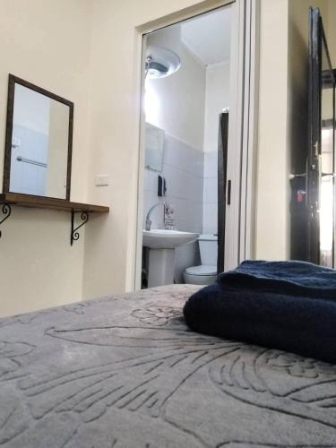 ein Schlafzimmer mit einem Bett, einem Waschbecken und einem Spiegel in der Unterkunft Al Midan Hotel in Amman