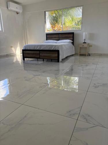 a bedroom with a bed and a large marble floor at VIP Hotel Haiti in Port-de-Paix