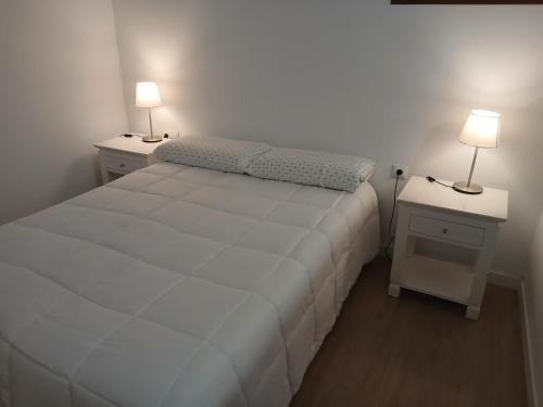 a bedroom with a white bed and two night stands at Loft Mamposo in Tacoronte