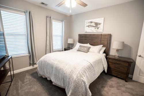 a bedroom with a bed with a white comforter and two windows at Memphis Charm in Memphis