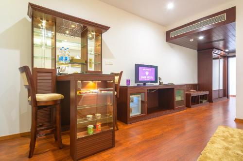 a room with a tv and a chair and a counter at Park Regis Goa in Arpora