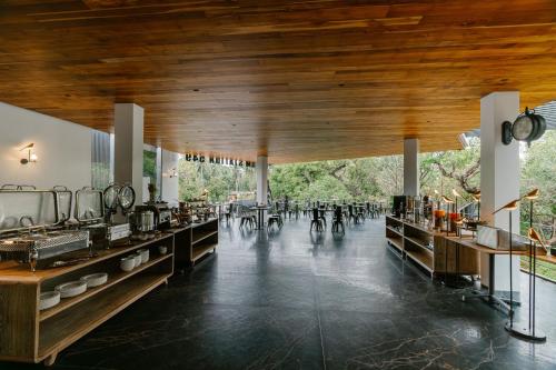 a dining room with tables and chairs and a wooden ceiling at Khanom Station 549 in Khanom