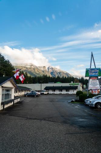 a parking lot with cars parked in front of a motel at Alpine Motel in Hope