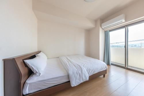 a bedroom with a bed and a large window at Jintai House501 in Fukuoka
