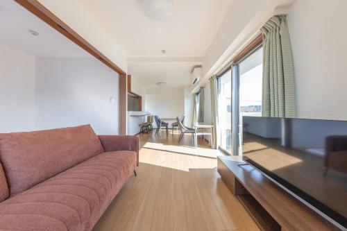 a living room with a couch and a large window at Jintai House401 in Hakata