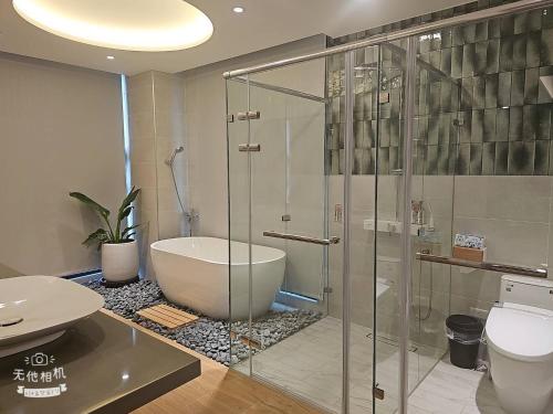 a bathroom with a shower and a tub and a toilet at Mysig Villa in Ch'eng-kung-li