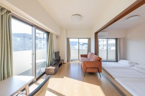 a living room with a bed and a couch at Jintai House401 in Hakata