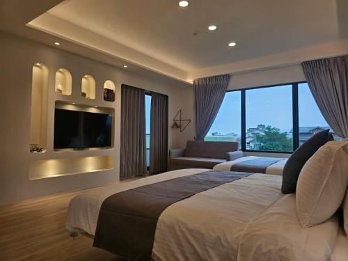 a hotel room with a large bed and a television at Mysig Villa in Ch'eng-kung-li