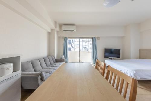 a living room with a bed and a couch at Jintai House201 in Fukuoka