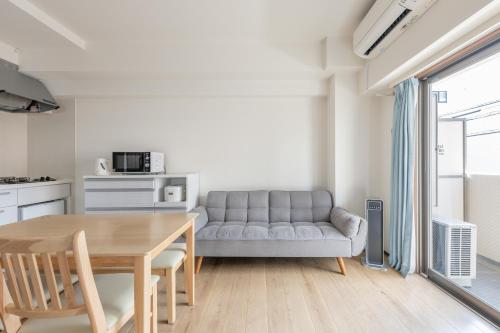 a living room with a table and a couch at Jintai House201 in Fukuoka