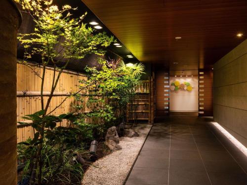 a hallway with plants on the side of a building at ibis Styles Kyoto Shijo in Kyoto