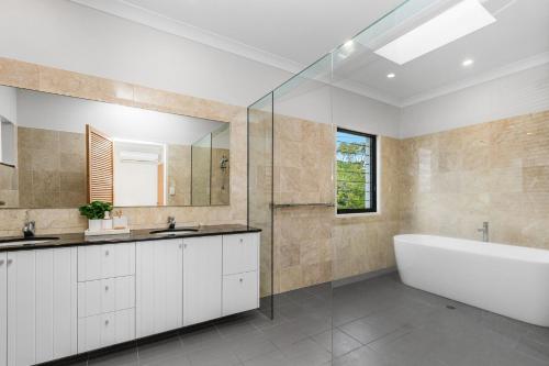 a bathroom with a tub and a sink at Luxurious Beachside Oasis with Ocean Views in Gold Coast