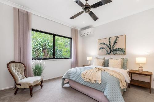 a bedroom with a bed and a ceiling fan at Luxurious Beachside Oasis with Ocean Views in Gold Coast