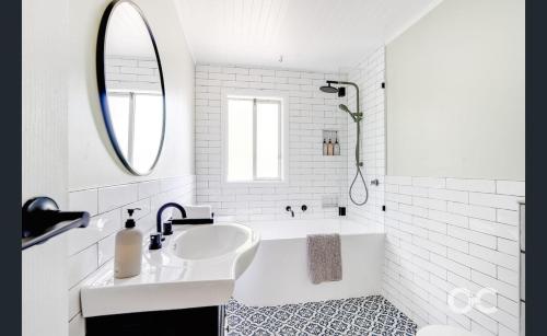 a white bathroom with a tub and a sink at Wollemi Cottage Orange in Orange