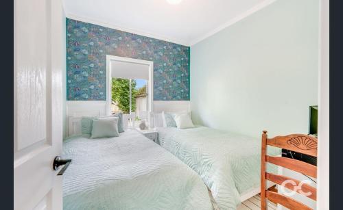two twin beds in a room with a window at Wollemi Cottage Orange in Orange
