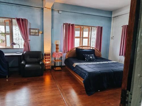 a bedroom with a bed and a chair and a desk at Phafan pool villa in Ban Pa Sang (1)