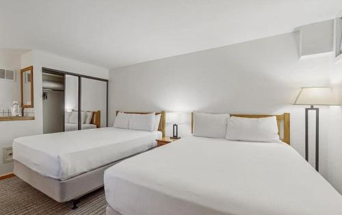 two beds in a hotel room with white sheets at 3 bdrm cottage in Predeal in Predeluţ