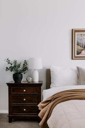a bedroom with a bed and a nightstand with a plant on it at Old Maffra Cottage in Maffra
