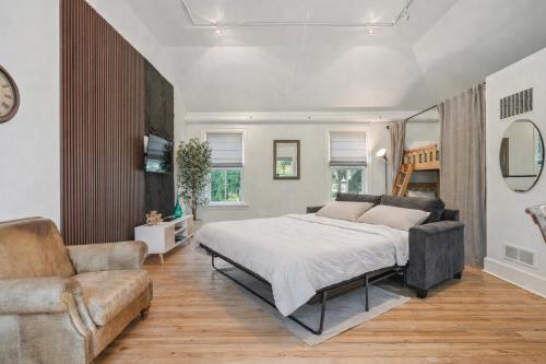 a bedroom with a bed and a couch and a chair at Niagara on the Lake Walkable Old Town Retreat in Niagara on the Lake