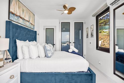 a bedroom with a large bed with a blue headboard at Casa Blue Laguna II |"Tropical Escape with Ocean Views I Steps to Bio Bay & Seven Seas I Guest Discounts on Boat Tours" in Fajardo