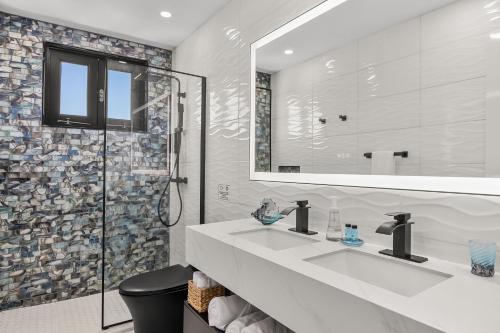 a bathroom with two sinks and a shower at Casa Blue Laguna II |"Tropical Escape with Ocean Views I Steps to Bio Bay & Seven Seas I Guest Discounts on Boat Tours" in Fajardo