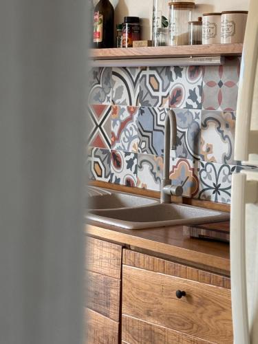 a kitchen with a sink and a tile wall at Casa Armonia in Favignana
