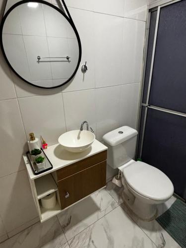 a bathroom with a toilet and a sink and a mirror at Rancho do Viajante Quarto B2 in Castro